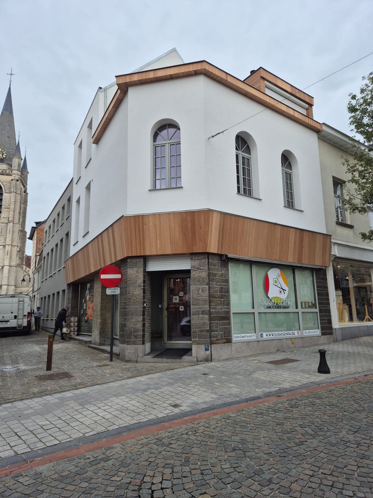 Vooraanzicht gevelrenovatie met crepi en meranti bekleding