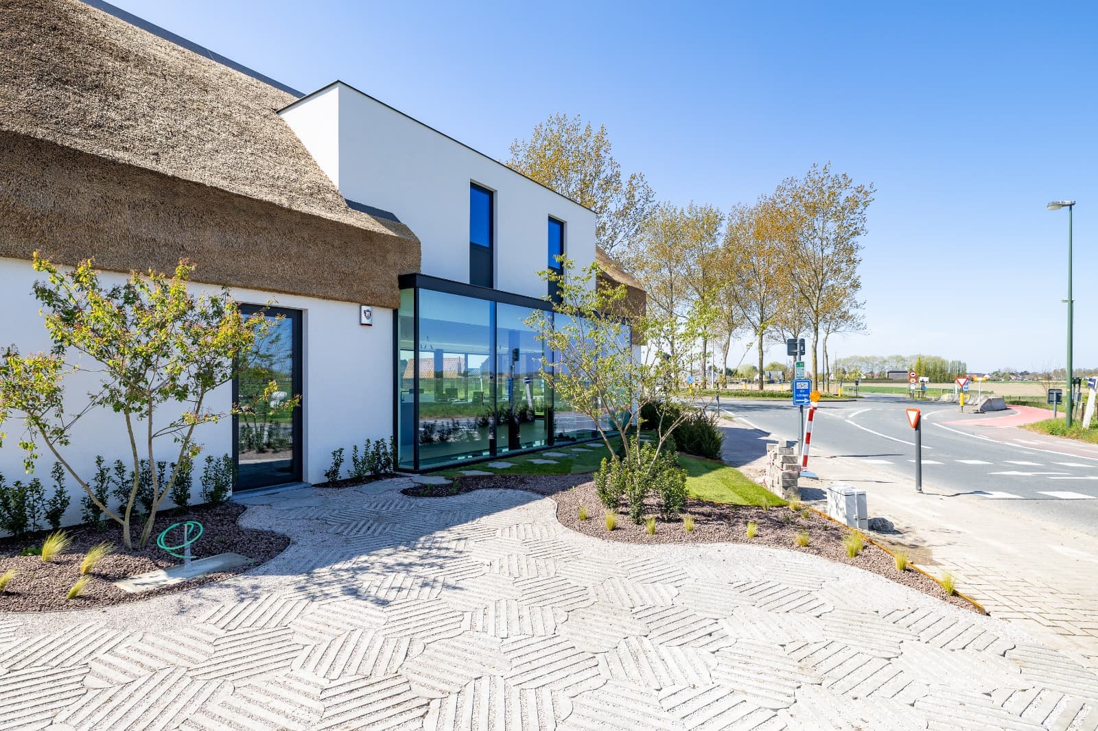 Zijaanzicht moderne nieuwbouw klassiek rieten dak en crepi